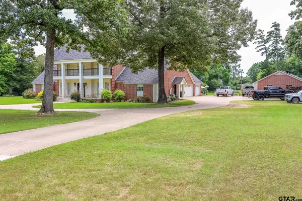 a front view of a house with a yard and trees