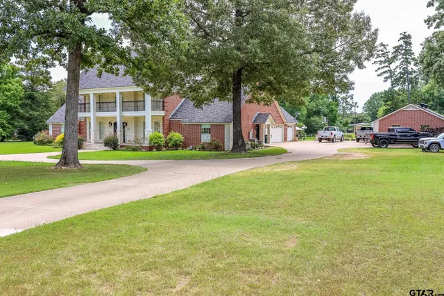 a front view of a house with a yard and trees