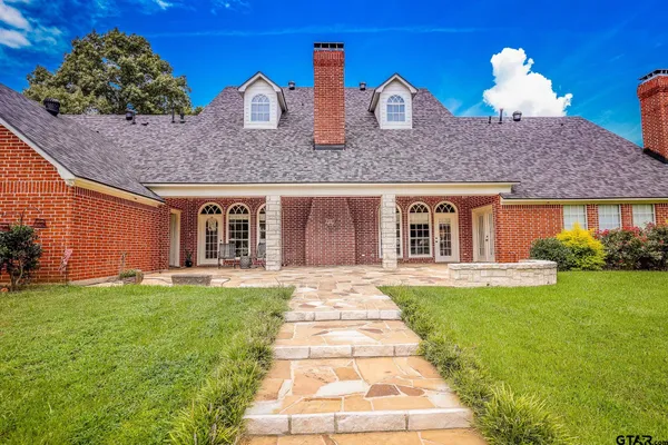 a front view of a house with a garden and yard