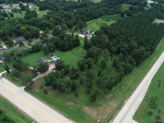 an aerial view of a house with garden space and a lake view