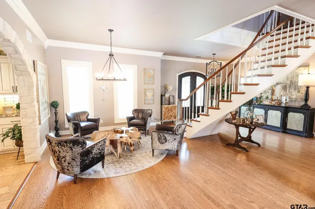a living room with furniture a wooden floor and a chandelier