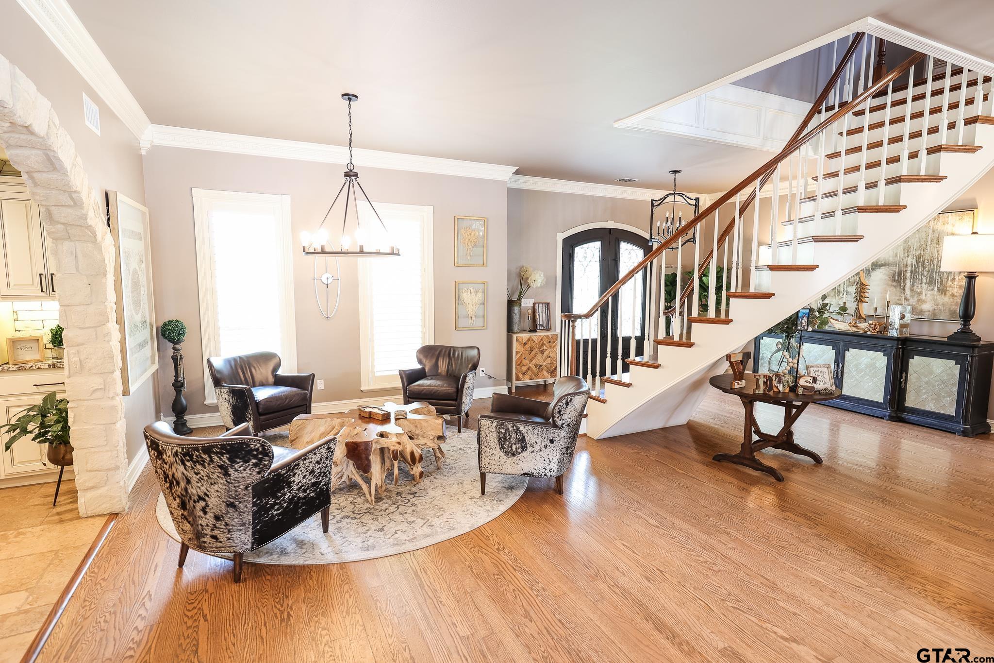 1415 West Sabine Street Carthage, TX 75633 - Photo 7 of 44 a living room with furniture a wooden floor and a chandelier