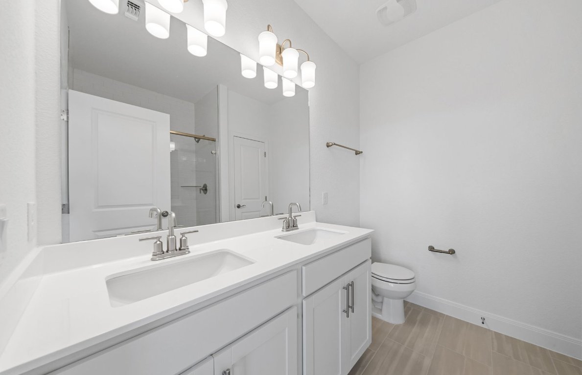 501 Maries Garden Georgetown, TX 78626 - Photo 12 of 24 a bathroom with a toilet a sink and mirror