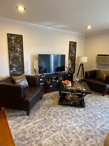 a living room with furniture a flat screen tv and a window