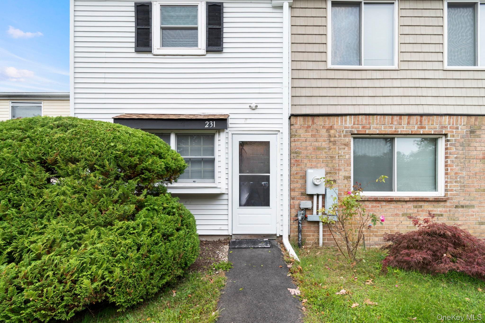 231 Hill Rise Calverton, NY 11933 - Photo 2 of 14 a front view of a house with garden