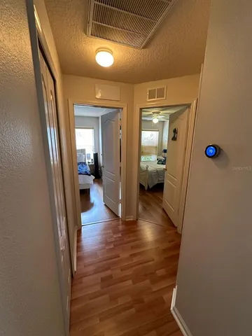 a view of a hallway view with wooden floor and living room