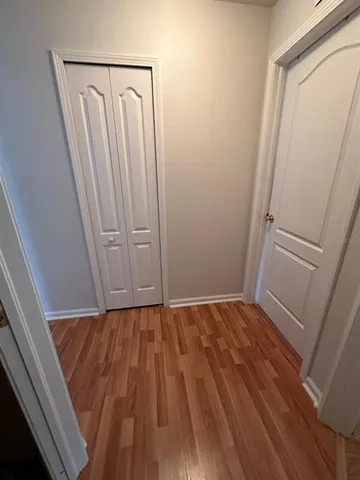 a view of walk in closet with wooden floor