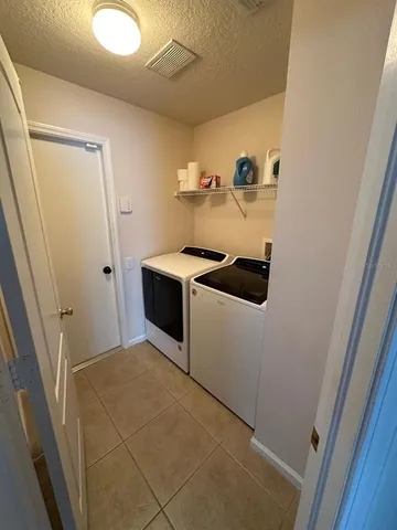 a view of an empty room with wooden floor and windows