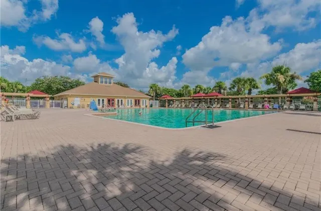 a view of a swimming pool with a patio and a yard