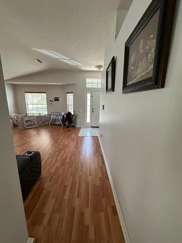 a view of a livingroom with wooden floor and furniture
