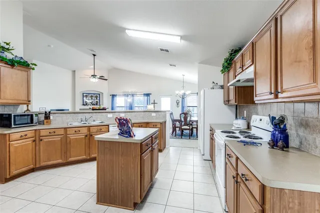 a kitchen with stainless steel appliances granite countertop a sink dishwasher stove top oven and cabinets