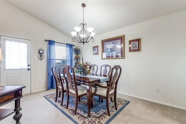 a view of a dining room with furniture a chandelier and wooden floor