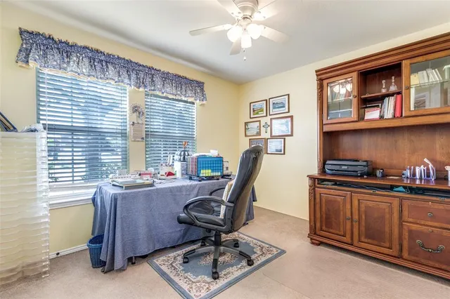 a view of a workspace with furniture and a window