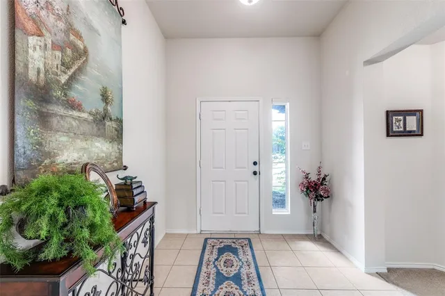 a view of a hallway with wooden floor and a potted plant
