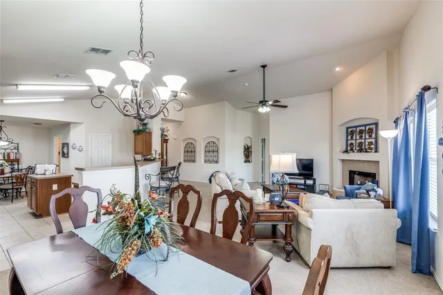 a living room with lots of white furniture and chandelier