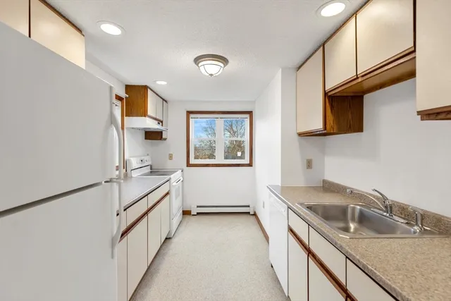 a kitchen that has a sink a stove and a microwave oven in it