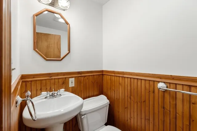 a bathroom with a toilet a sink and mirror