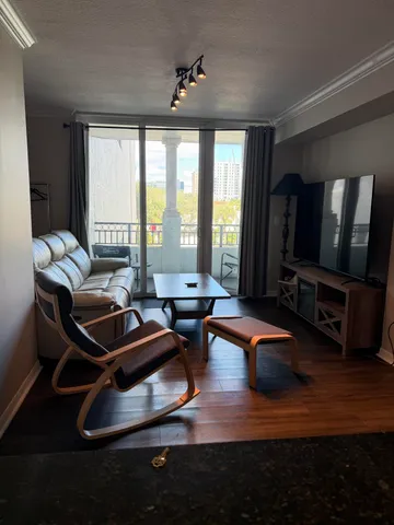 a living room with furniture a flat screen tv and wooden floor