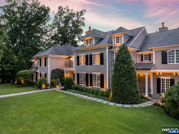 a front view of a house with a yard and trees