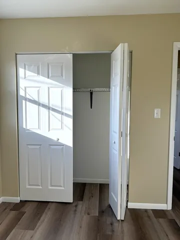 a view of walk in closet with wooden floor