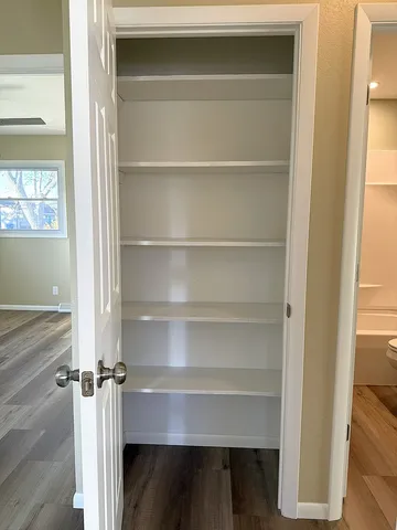 a view of walk in closet with empty racks