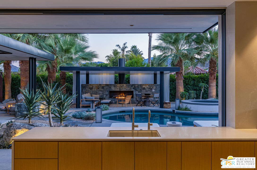 72453 Rancho Road Rancho Mirage, CA 92270 - Photo 48 of 60 a view of a house with a balcony and floor to ceiling windows with potted plants