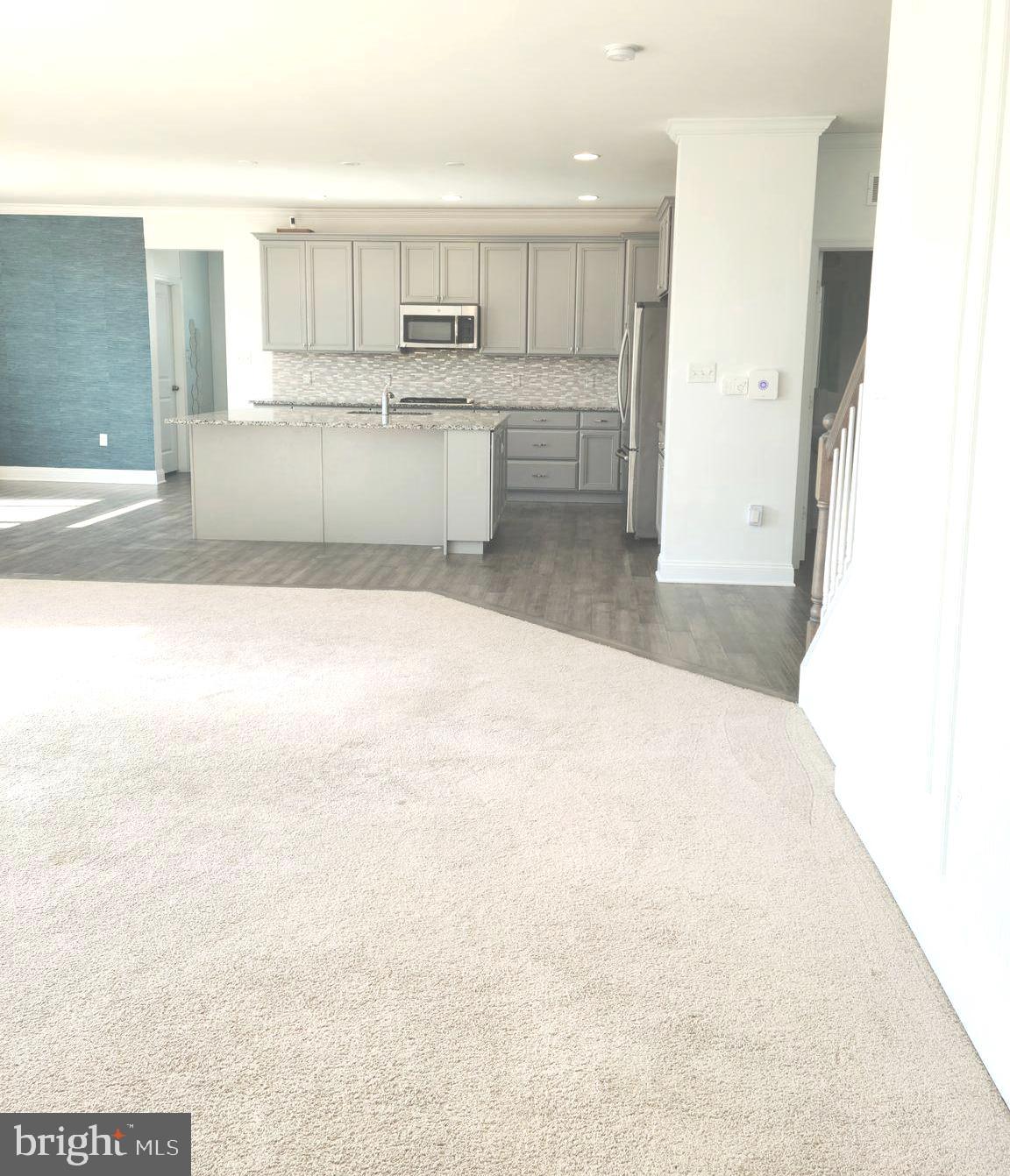 1756 Michelangelo Drive Middletown, DE 19709 - Photo 6 of 24 a open hall with kitchen island sink refrigerator and stove