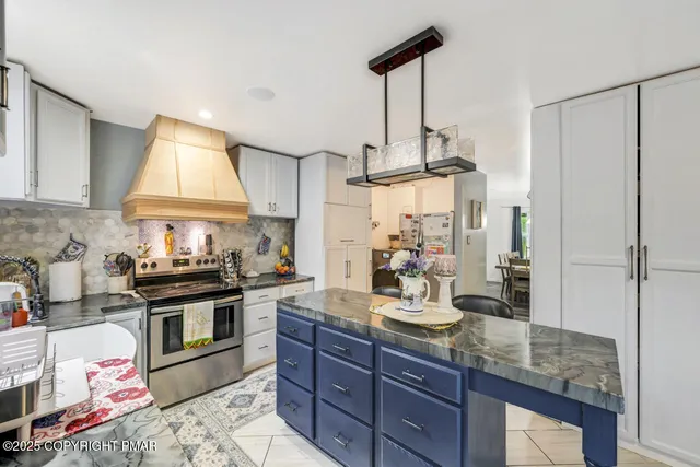 a kitchen with stainless steel appliances granite countertop a stove a sink and a refrigerator