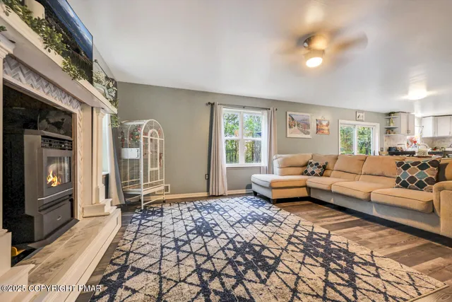 a kitchen with stainless steel appliances granite countertop a stove a sink dishwasher a dining table and chairs with wooden floor