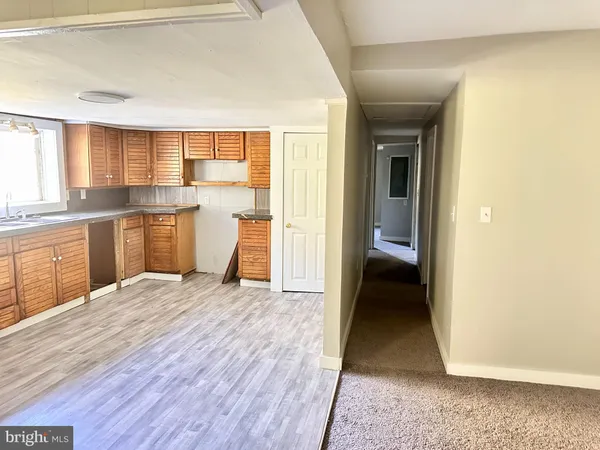 a view of a kitchen with a sink and dishwasher with white walls