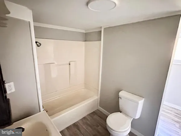a white toilet sitting next to a bath tub shower