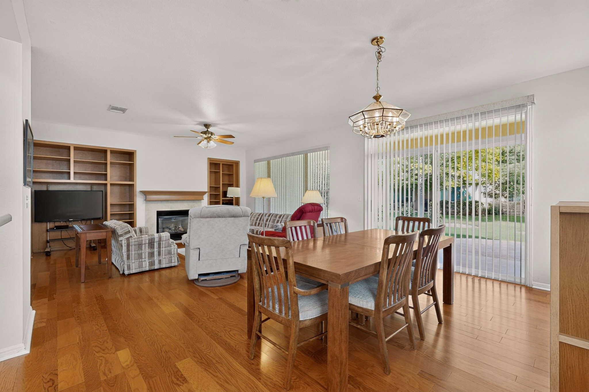 207 Red Poppy Trail Georgetown, TX 78633 - Photo 8 of 31 Hardwood floors and built-in shelving complement this inviting open-plan living and dining area, perfect for entertaining.