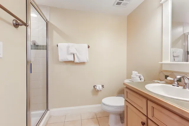 a bedroom with a bed and dresser with wooden floor