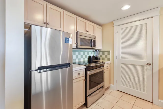 a kitchen with stainless steel appliances granite countertop a refrigerator and a stove top oven