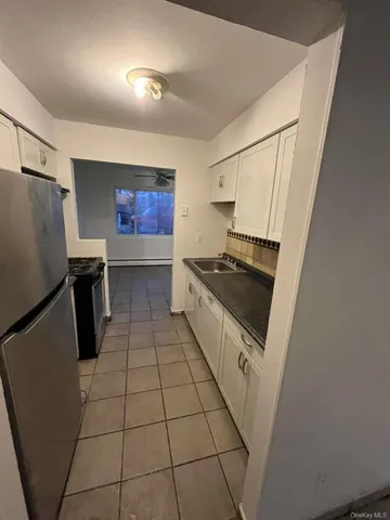 a kitchen with granite countertop a stove a sink and a refrigerator