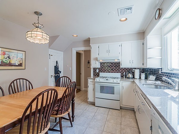 50 Blake Road Brookline, MA 02445 - Photo 7 of 18 a kitchen with stainless steel appliances granite countertop a sink dishwasher a stove a dining table and chairs