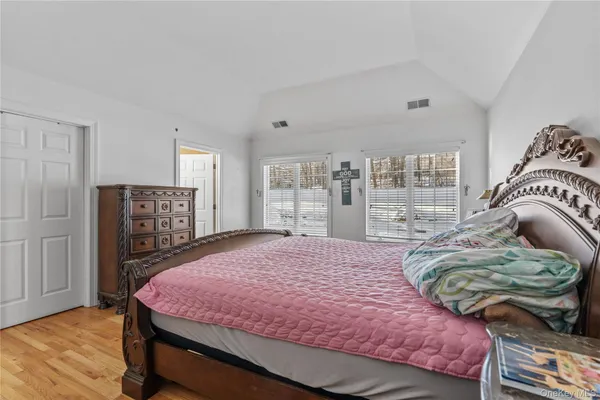 a bedroom with a bed and a dresser next to a window