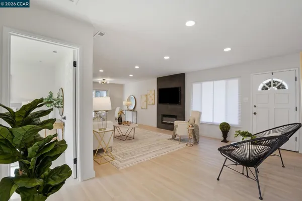 a living room with furniture potted plant and a flat screen tv