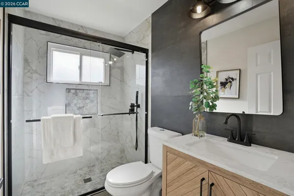 a bathroom with a sink a toilet and shower