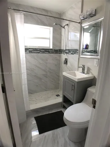 a bathroom with a sink toilet and shower