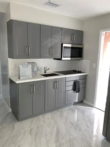 a kitchen with a sink a stove and cabinets