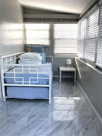 a living room with a bed furniture and a large window