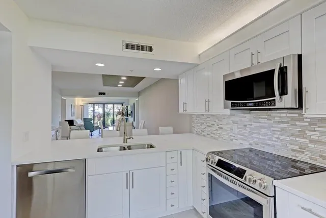 a kitchen with granite countertop a sink and a stove top oven