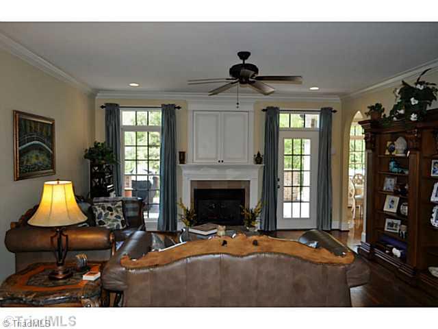 8401 Parkchester Place Oak Ridge, NC 27310 - Photo 2 of 16 Den/Family/Great Room. This large great room offers a gas log fireplace with an area for a flat screen TV behind the doors over the chimney piece.