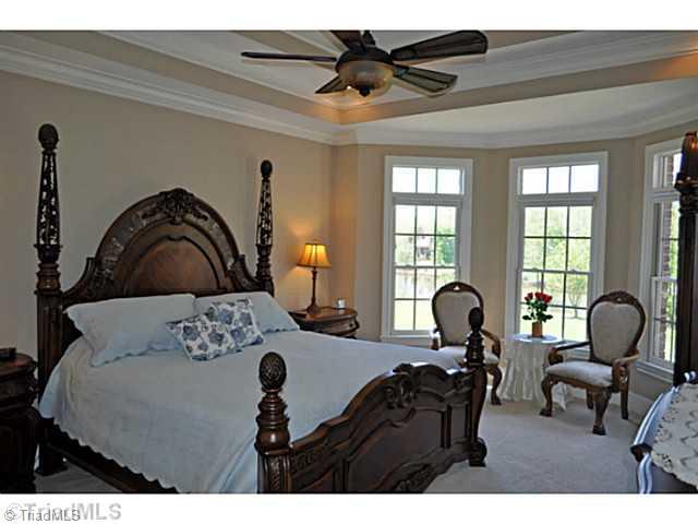 8401 Parkchester Place Oak Ridge, NC 27310 - Photo 7 of 16 Master Bedroom. The spacious 1st floor master suite enjoys a sitting area, tray ceiling and a great view of the pond.