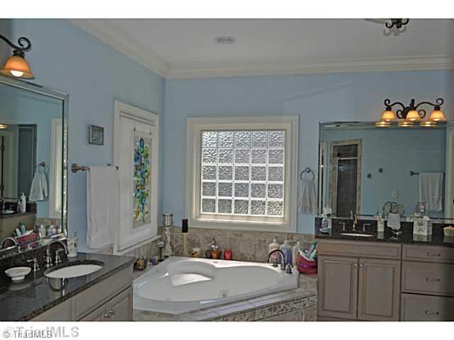 8401 Parkchester Place Oak Ridge, NC 27310 - Photo 8 of 16 Master Bath/Spa. The master suite s spa bath enjoys a jetted tub, a walk-in shower with His & Her shower heads as well as a private water closet & huge walk-in closet.