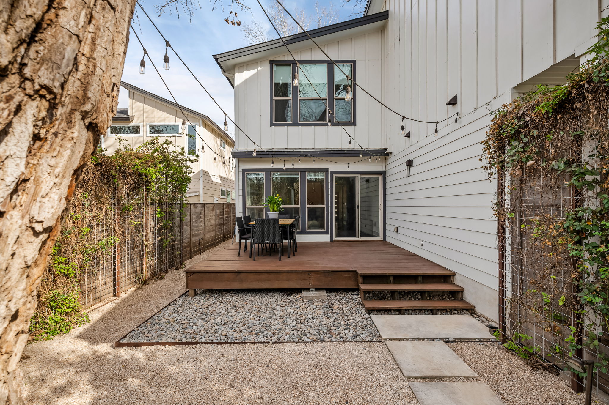 1124 Linden Street, Unit B Austin, TX 78702 - Photo 19 of 26 Rear view of house with outdoor dining space, a fenced backyard, a deck, and board and batten siding