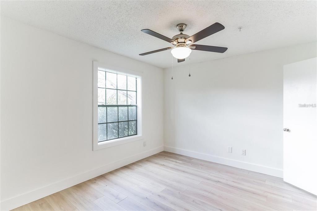 241 Afton Square, Unit 102 Altamonte Springs, FL 32714 - Photo 7 of 12 an empty room with wooden floor fan and windows