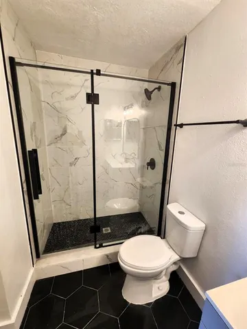 a bathroom with a toilet a sink and a shower