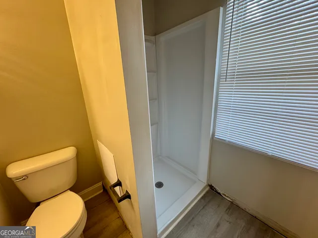 a bathroom with a toilet and a shower